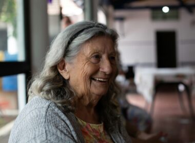 smiling woman in gray cardigan
