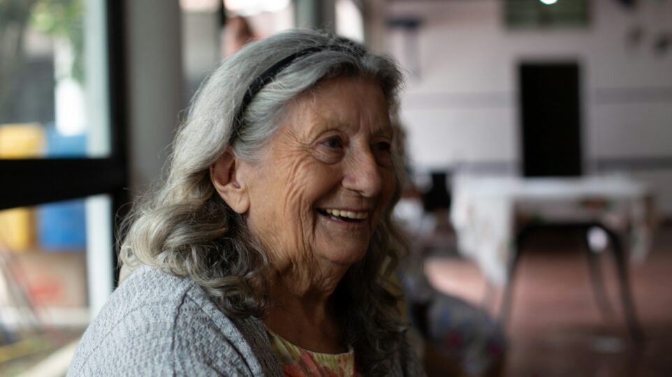 smiling woman in gray cardigan